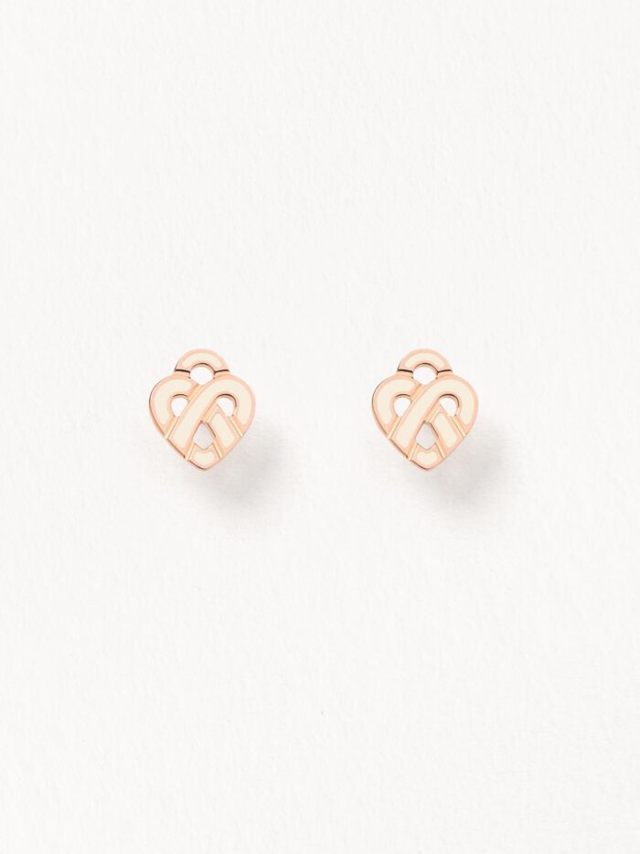 Boucles D'oreilles Poiray Coeur Entrelacé Or Rose Et Émail Ivoire Immédiatement reconnaissable, le Cœur Entrelacé conserve ses lignes épurées et graphiques, ses courbes singulières et généreuses qui célèbrent tous les amours. Couleur ivoire, l’émail fait discrètement ressortir la délicatesse de l’or rose, dont le modèle se décline en pendentif, boucles d’oreilles, bracelet, mais également sur un pendentif au format plus généreux.